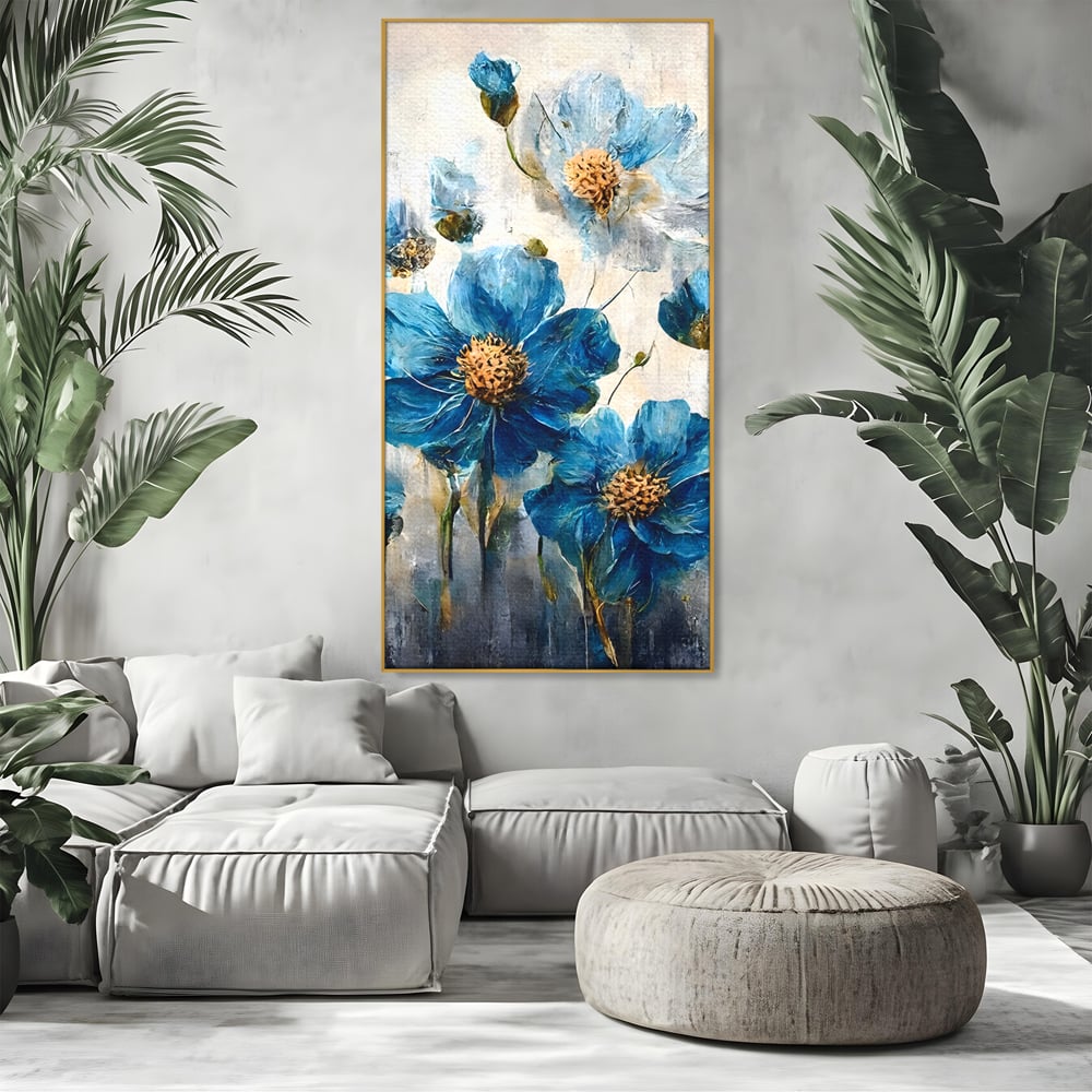 Tablou canvas cu pictura verticala cu flori albastre, in rama de aluminiu auriu, pe perete intr-un living